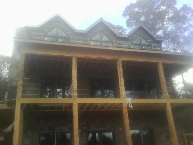 Dormers and porch framing on a large log home under construction — Roof Coating work by our crew in Endicott